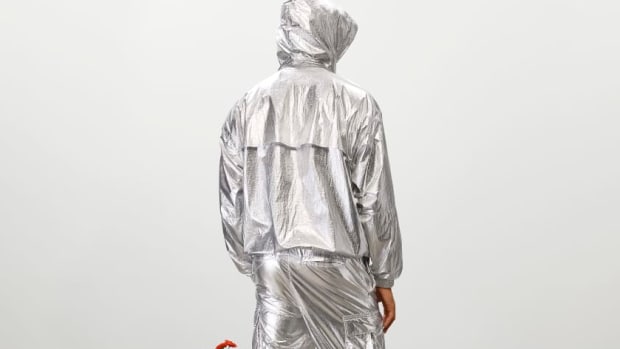 Model wearing metallic tracksuit.